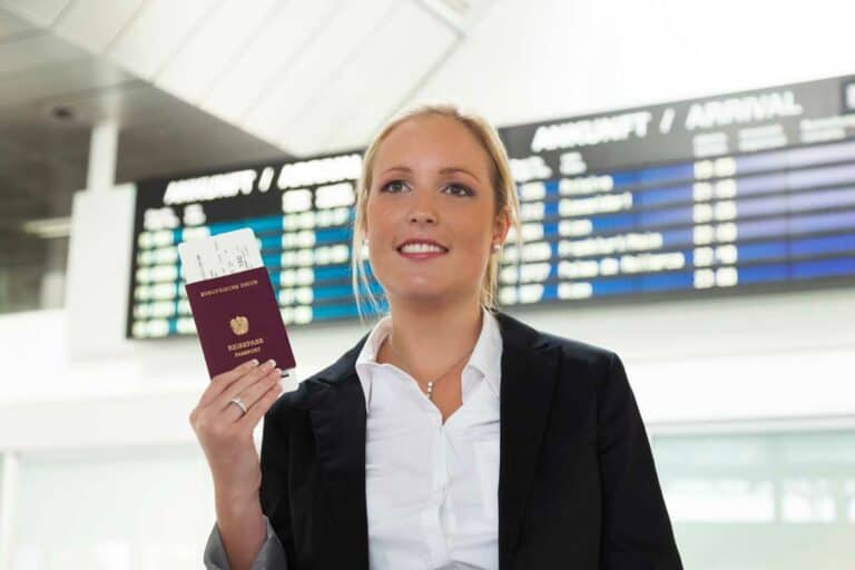 אישה מחזיקה דרכון אוסטרי עם כרטיס טיסה שיוצא ממנו
